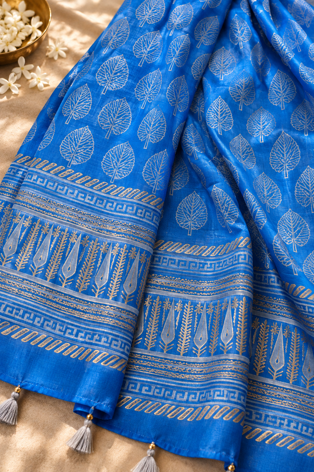 Close-up of blue Chanderi dupatta fabric, leaf motifs, printed border, and tassel detailing
