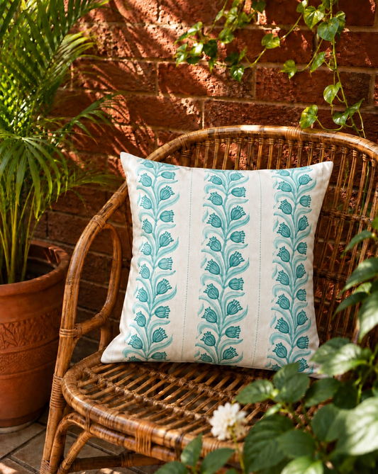 Teal hand block printed pure cotton cushion cover on a rattan chair