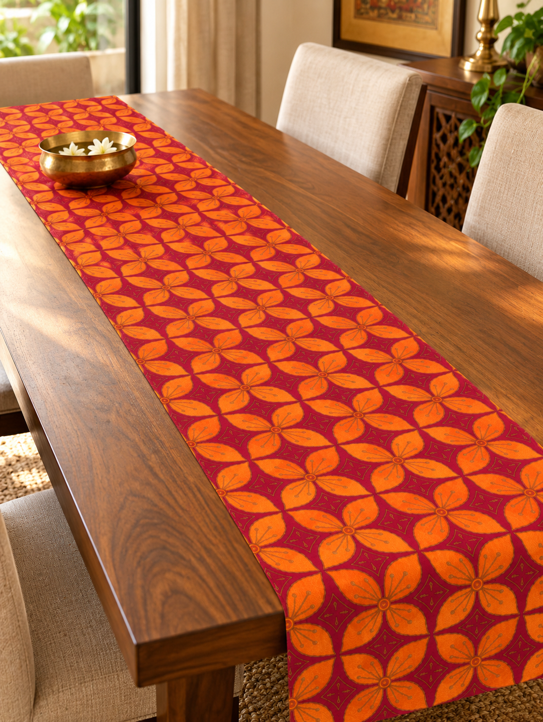 Maroon and orange floral dupion silk table runner laid along a wooden dining table