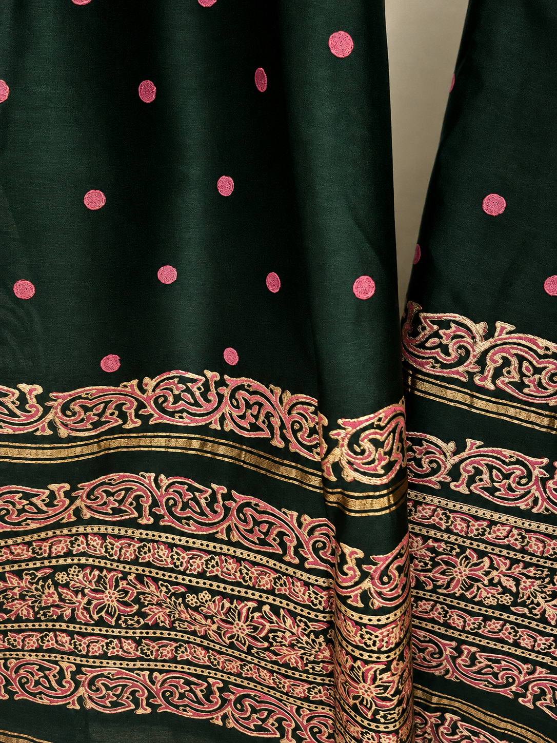 Close-up of pink dot motifs and floral border on forest-green dupatta