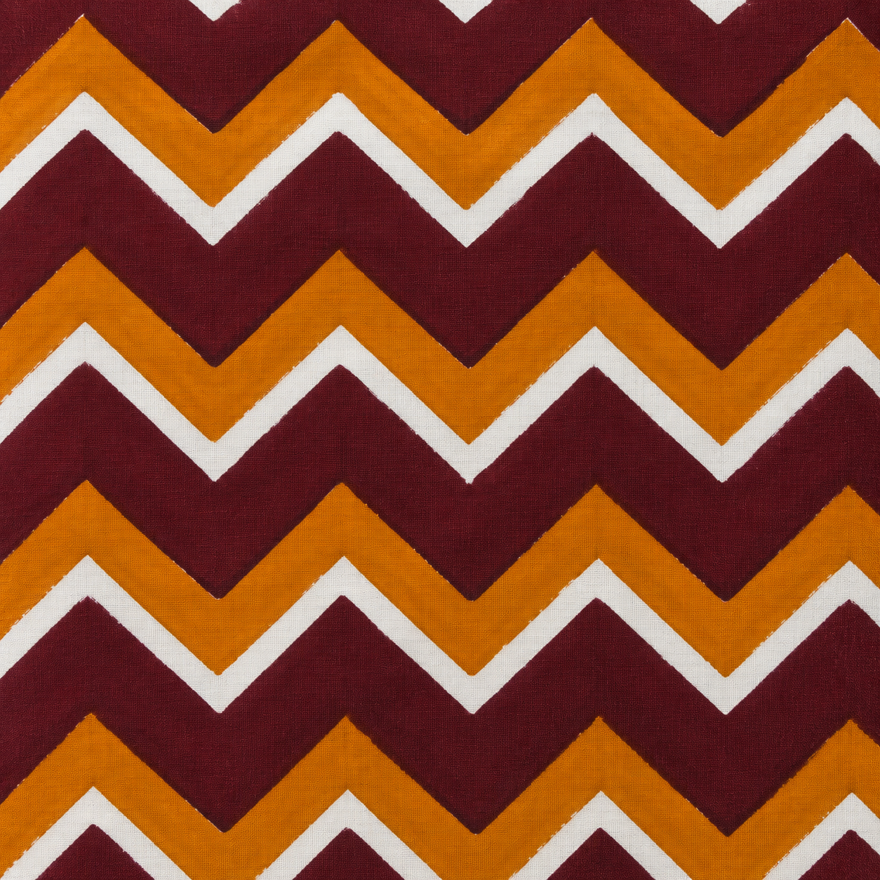 Close up of maroon mustard white chevron hand block print on cotton cushion cover